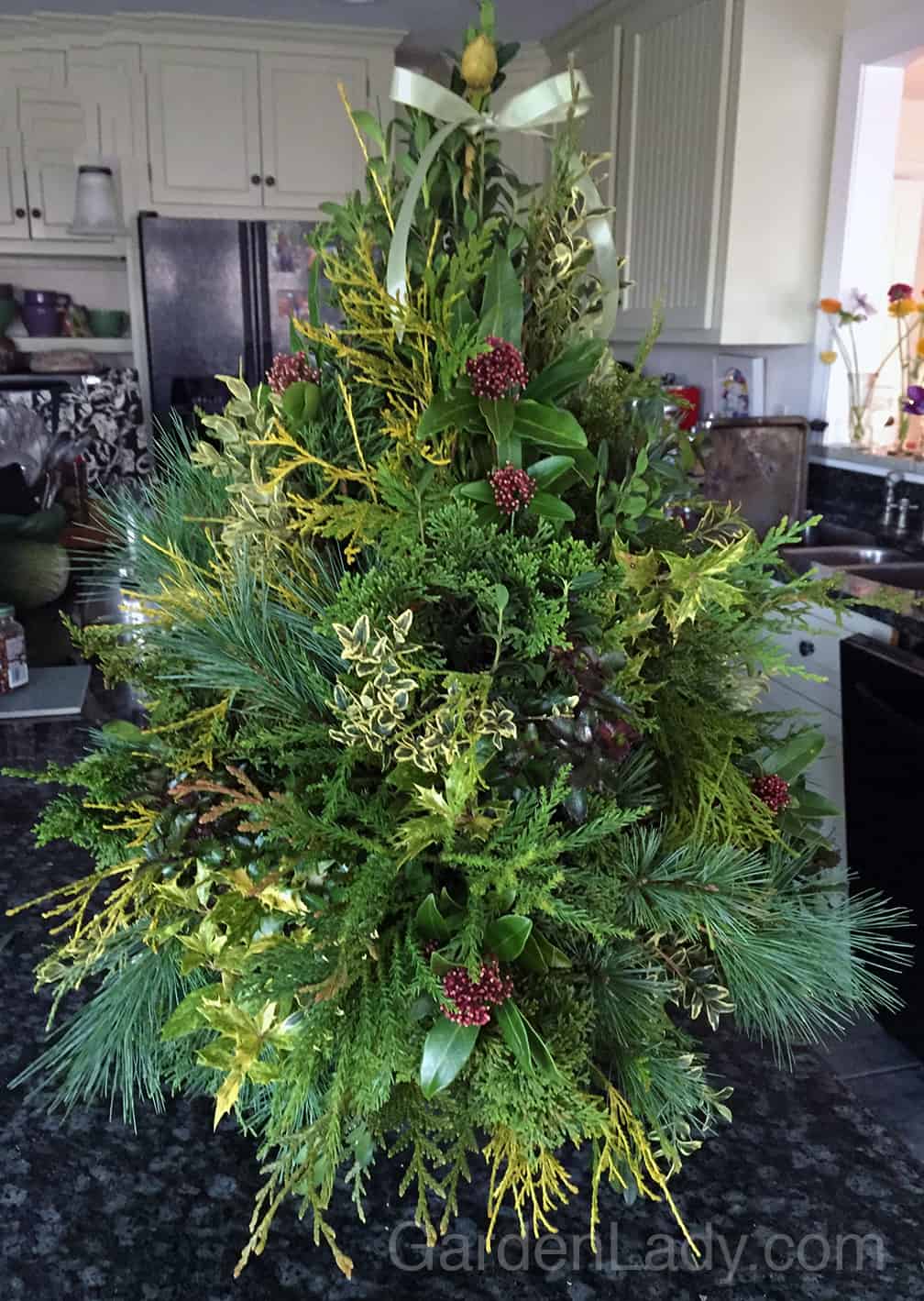 I made a mixed greens tree in Oasis in the same manner that boxwood trees are created. I was especially pleased with the Rhododendron bud used at the top of the tree.